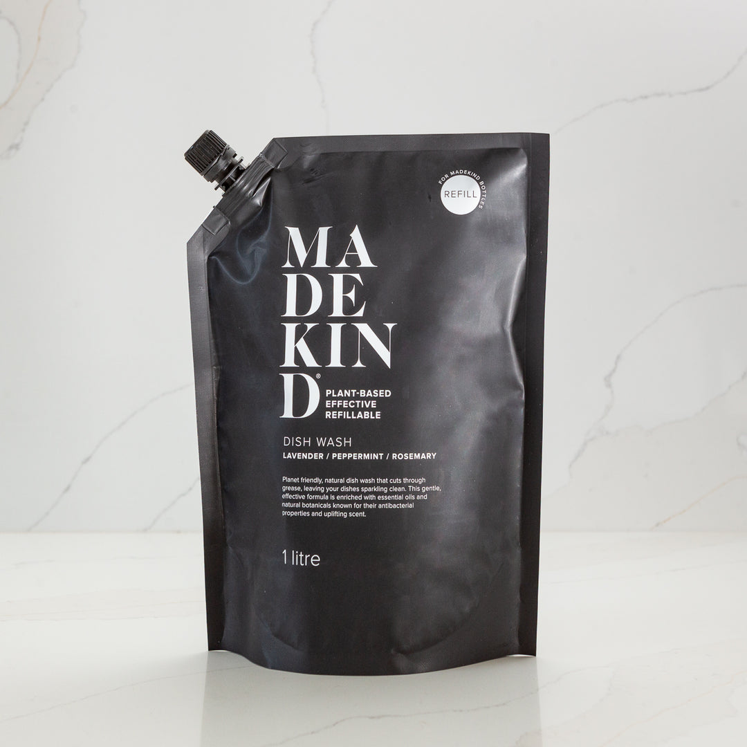 Black sustainable refill pouch with 'MadeKind' branding on a white kitchen background