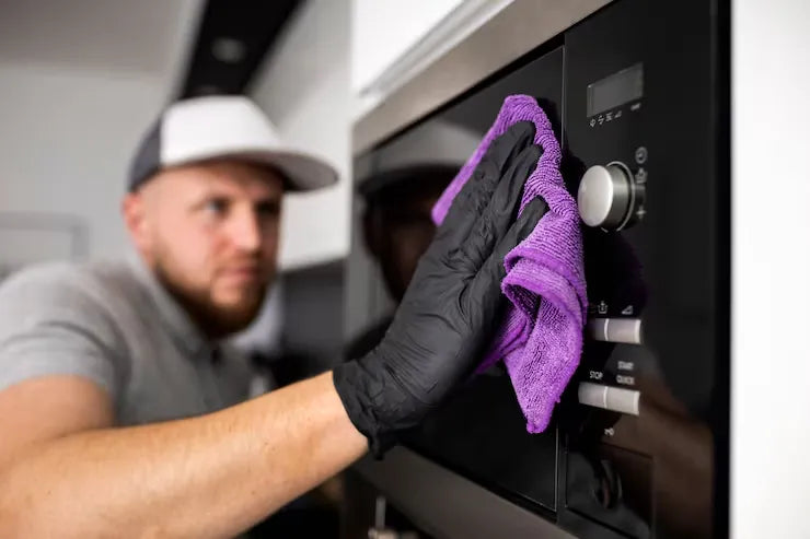 Man cleaning a microwave 