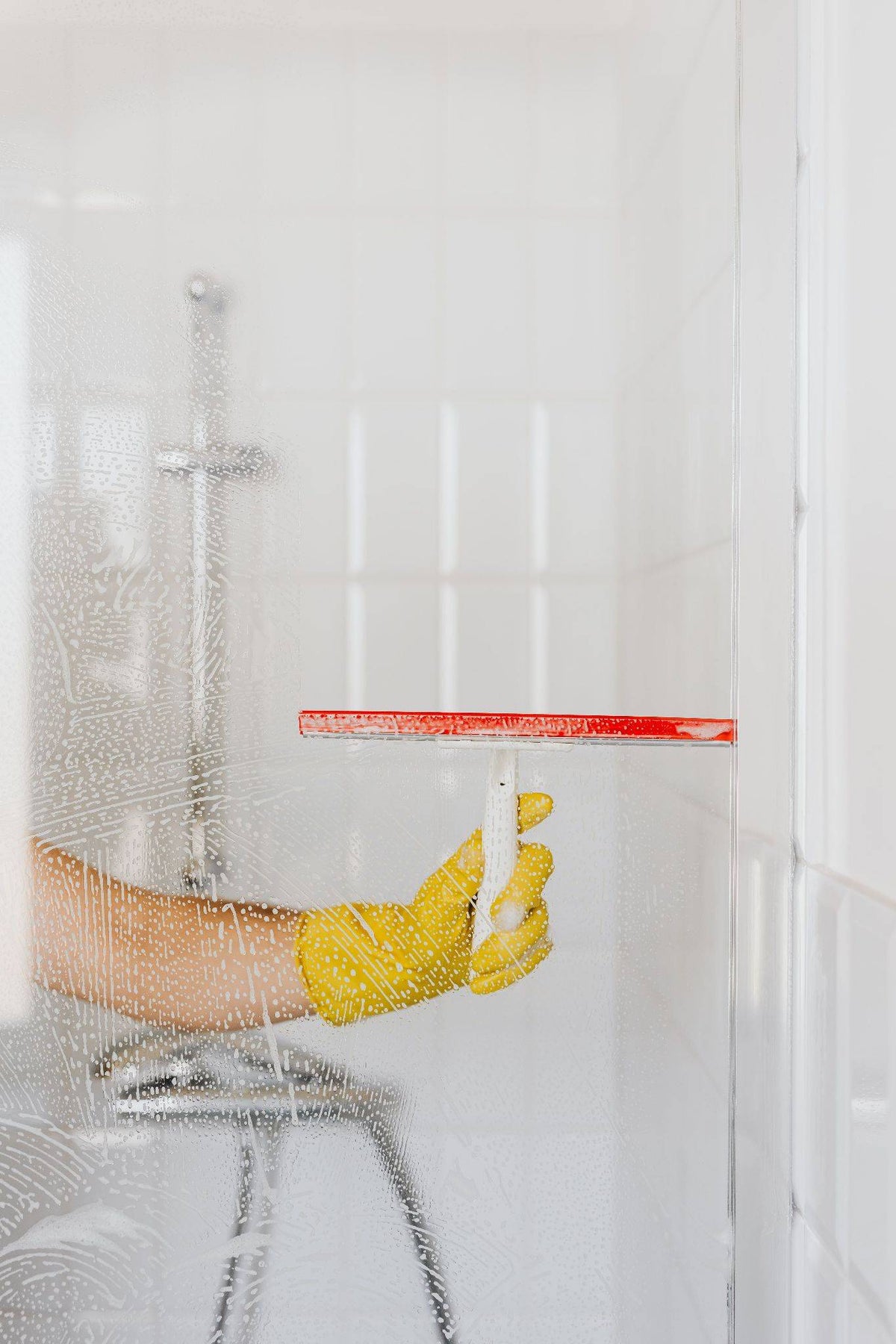 Person cleaning a glass shower