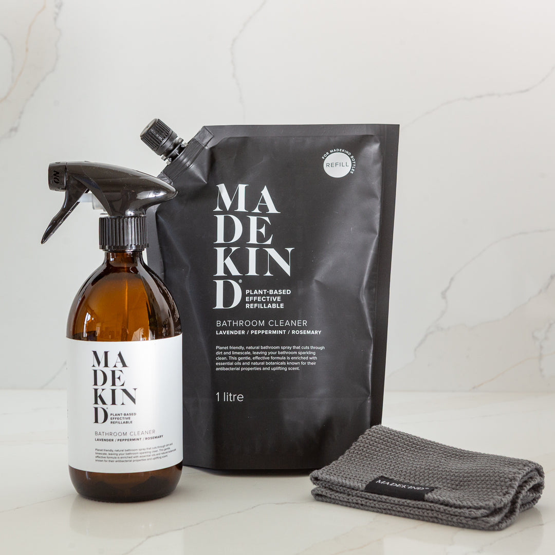 Madekind cleaning products including a spray bottle, 1 litre refill pouch, and grey dish cloth on a light background