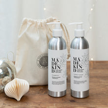 Load image into Gallery viewer, Photo of MadeKind natural eco shampoo &amp; conditioner with orange blossom &amp; grapefruit essential oils, in a gift bag, surrounded by christmas decorations and sparkly lights
