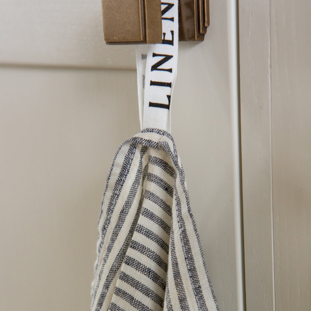 Photo of a Grey Striped Tea Towel hanging from a hook