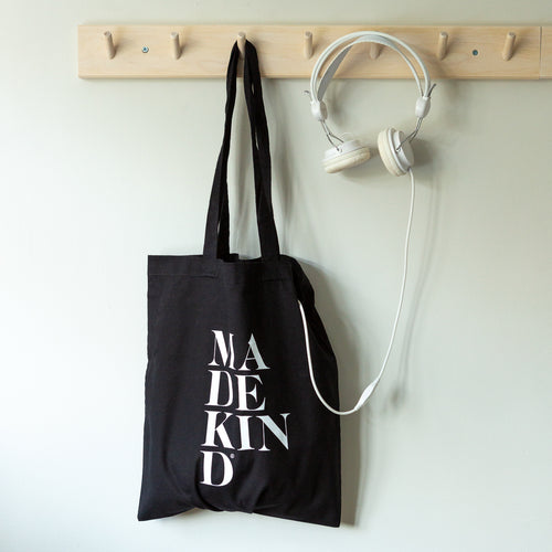 MadeKind black tote bag hanging on a peg 