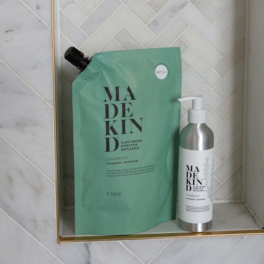 MadeKind Natural Shampoo Refill Pouch and refillable aluminium bottle on a shower shelf.