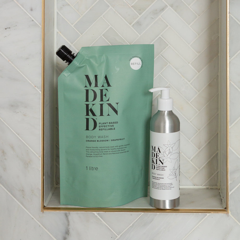 MadeKind Body Wash Refill next to a MadeKind aluminium refillable bottle in a shower
