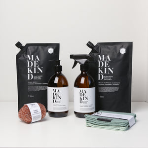 Photo of the MadeKind Kitchen Cleaning Kit; Multi Surface Cleaner and Dish Wash refills with 2 empty amber glass bottles, copper scourers and green dishcloths
