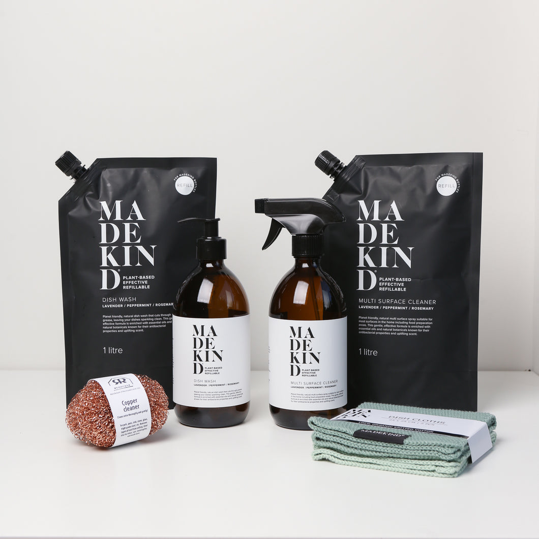 Photo of the MadeKind Kitchen Cleaning Kit; Multi Surface Cleaner and Dish Wash refills with 2 empty amber glass bottles, copper scourers and green dishcloths