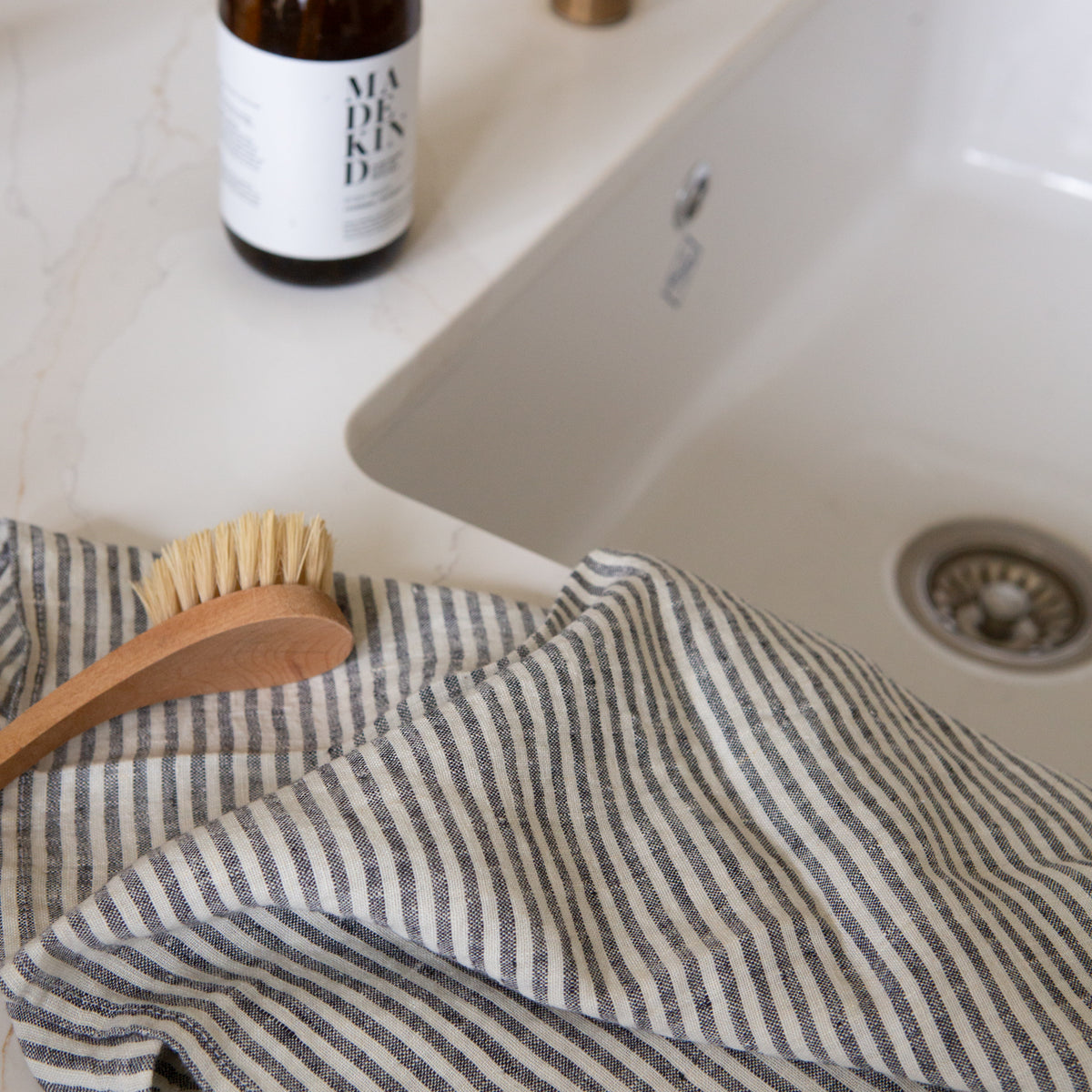 Photo of a striped tea towel next to a kitchen sink