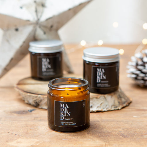 Madekind soy wax candle in small amber glass jar on table with Christmas decorations