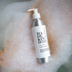 Photo of a Madekind natural Body wash, lavender & geranium scented shower gel in an aluminium bottle, laying on bubbles.