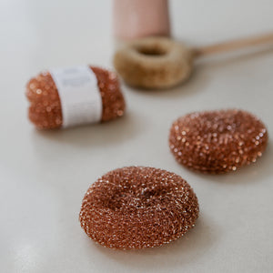 Photo of Redecker copper scourers with a brush in the backdgound