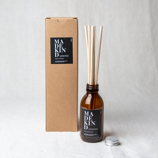 Photo of MadeKind Awaken aromatherapy reed diffuser in glass amber bottle. Pure essential oil blend includes Rose, Jasmine and Ylang Ylang. Reeds come included and presented in a Kraft gift box.